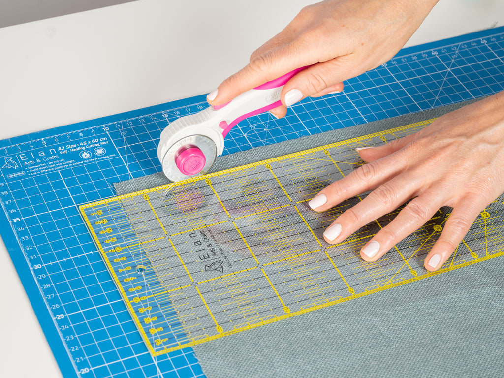 A real life view of a quilting rulers used in combination with the Rotary cutter on a cutting mat.